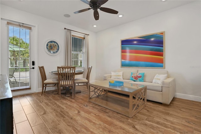 living room with a wealth of natural light, ceiling fan, and light hardwood / wood-style floors