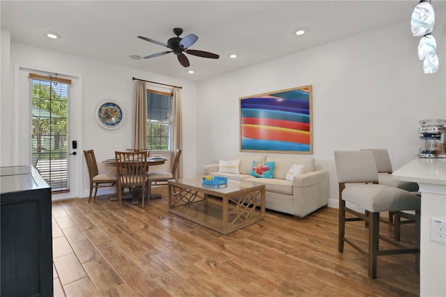 living room with hardwood / wood-style flooring, ceiling fan, and a wealth of natural light