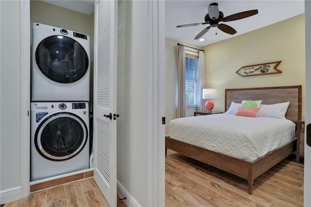 interior space with stacked washer / dryer, ceiling fan, and light hardwood / wood-style flooring