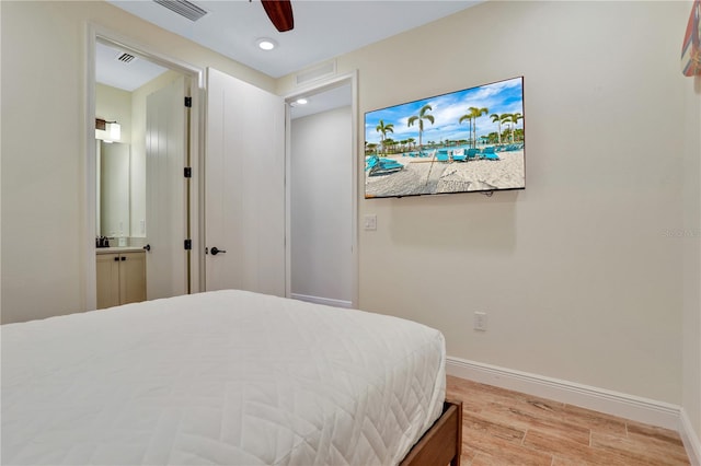 bedroom with hardwood / wood-style flooring, ceiling fan, and ensuite bath