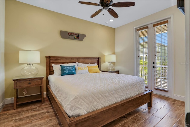 bedroom with wood-type flooring, ceiling fan, access to outside, and multiple windows