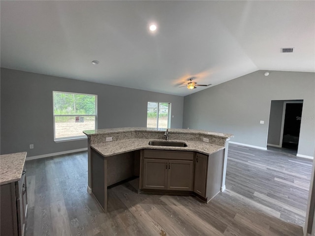 kitchen with ceiling fan, sink, dark hardwood / wood-style floors, vaulted ceiling, and a kitchen island with sink