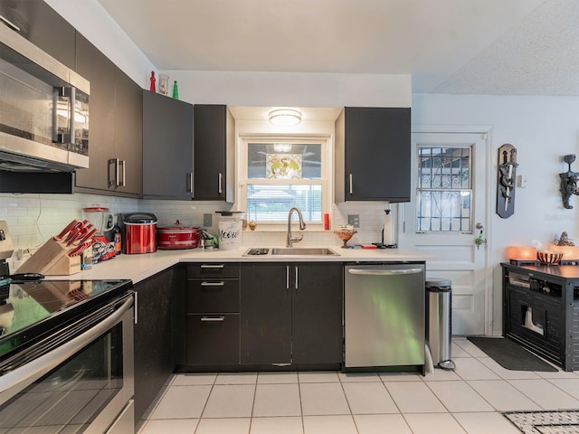 kitchen with sink, tasteful backsplash, light tile floors, and stainless steel appliances