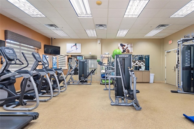 workout area with a drop ceiling and light colored carpet