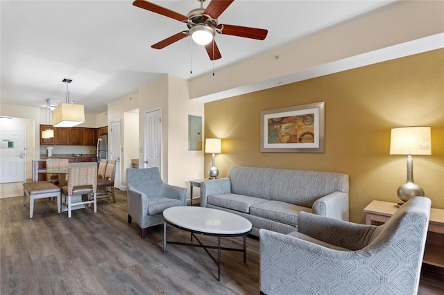 living room featuring ceiling fan, electric panel, and hardwood / wood-style floors