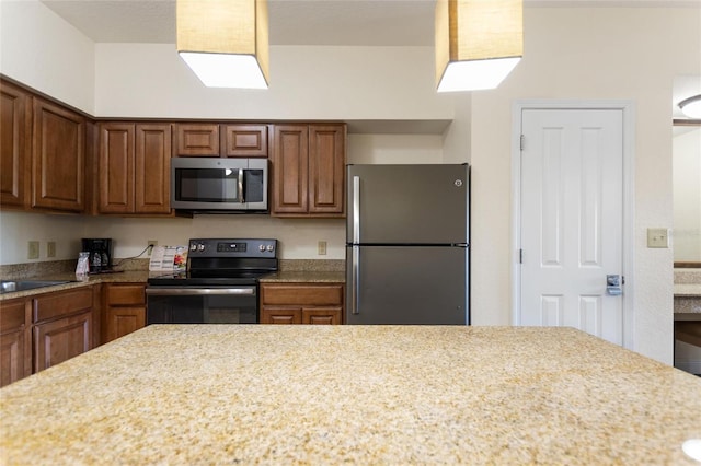 kitchen featuring light stone countertops and stainless steel appliances