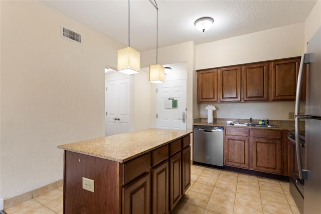 kitchen featuring light tile patterned floors, appliances with stainless steel finishes, a textured ceiling, pendant lighting, and a center island