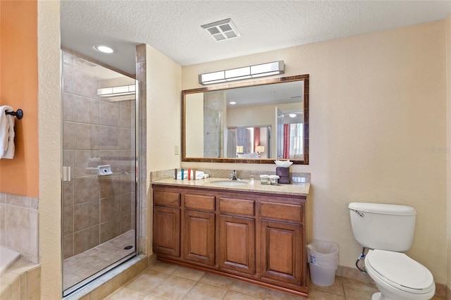 bathroom with toilet, tile patterned flooring, a shower with shower door, vanity, and a textured ceiling