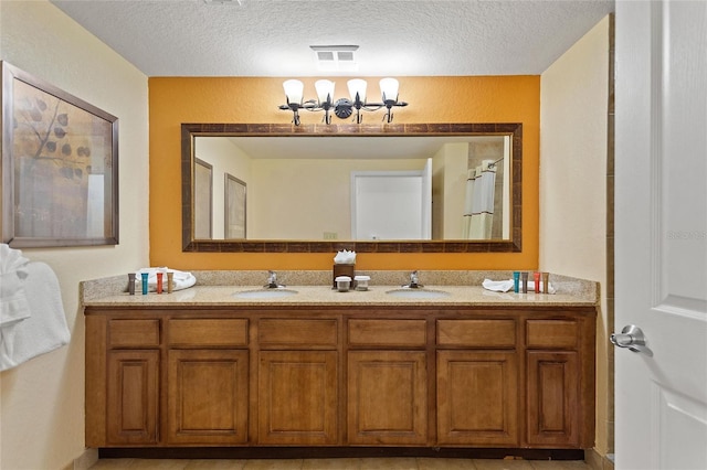 bathroom with vanity, a textured ceiling, and tile patterned flooring