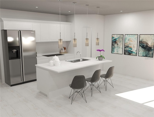 kitchen featuring white cabinets, stainless steel refrigerator with ice dispenser, an island with sink, sink, and hanging light fixtures