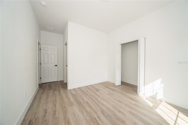 unfurnished bedroom featuring light hardwood / wood-style floors and a closet