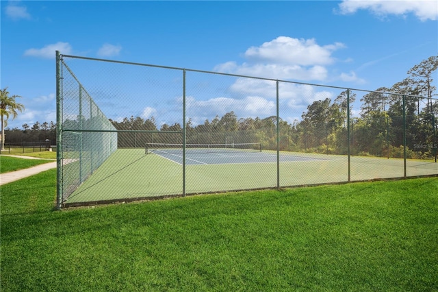 view of tennis court featuring a lawn