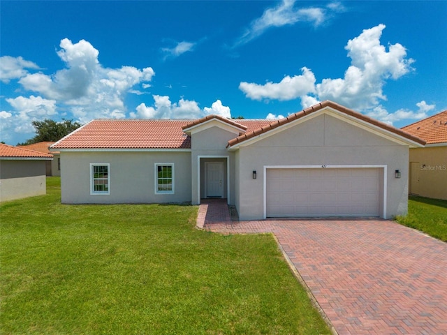 mediterranean / spanish home featuring a front lawn and a garage