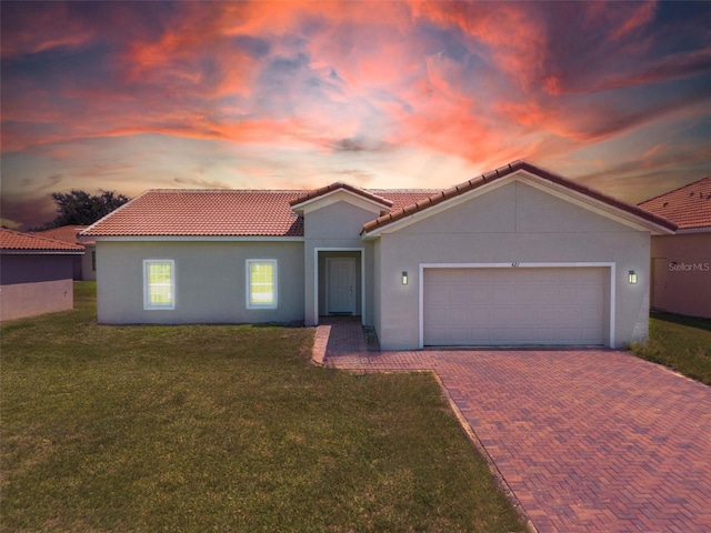 view of front facade with a yard and a garage