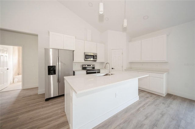 kitchen featuring white cabinets, stainless steel appliances, sink, hanging light fixtures, and a kitchen island with sink