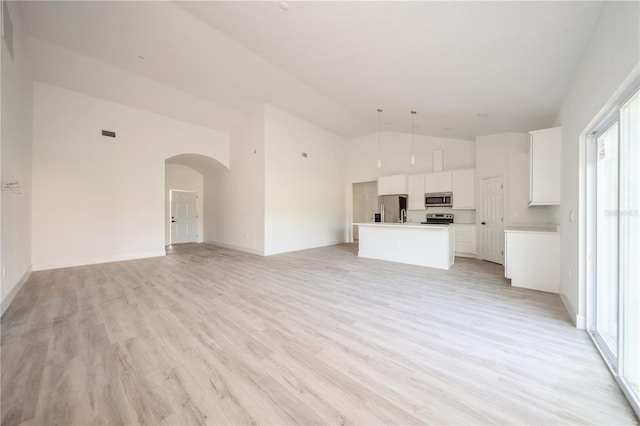 unfurnished living room with light hardwood / wood-style floors and lofted ceiling