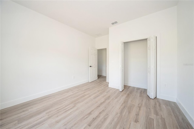 unfurnished bedroom featuring a closet and light hardwood / wood-style flooring