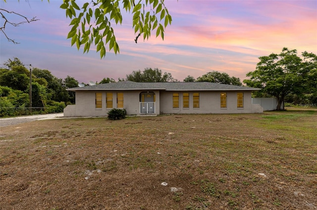 single story home with a lawn