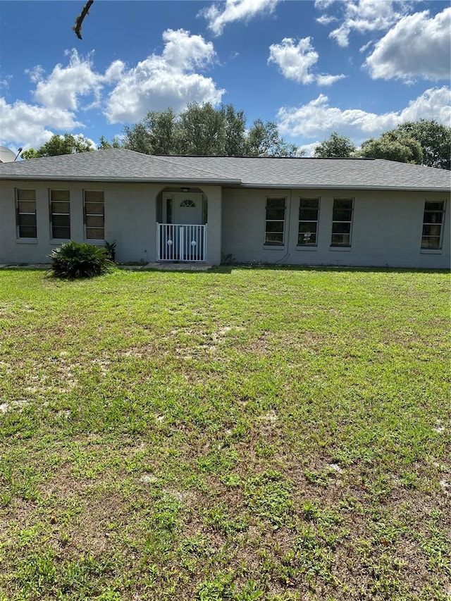 rear view of house featuring a lawn