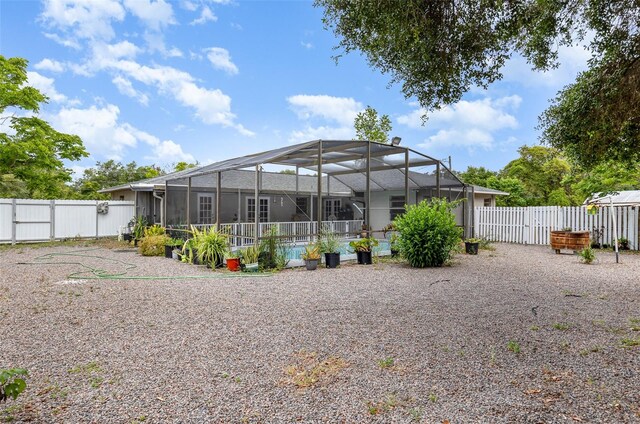 back of property featuring a swimming pool and glass enclosure