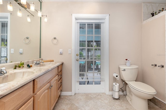 bathroom with vanity, toilet, and tile floors