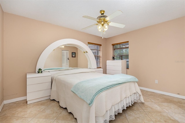 tiled bedroom featuring ceiling fan and a textured ceiling