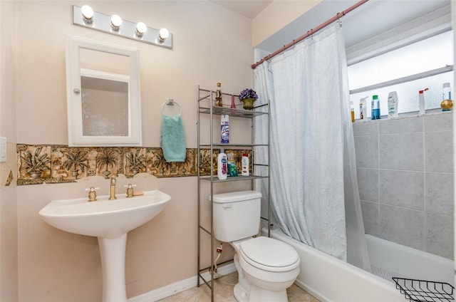 bathroom with tile flooring, toilet, and shower / bath combo with shower curtain