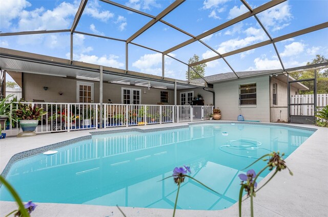 view of swimming pool with glass enclosure and a patio area