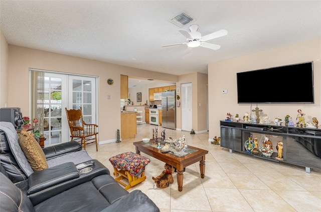 tiled living room featuring french doors, ceiling fan, and a textured ceiling