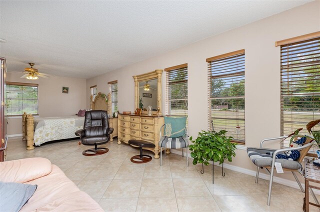 tiled living room featuring plenty of natural light, ceiling fan, and a textured ceiling