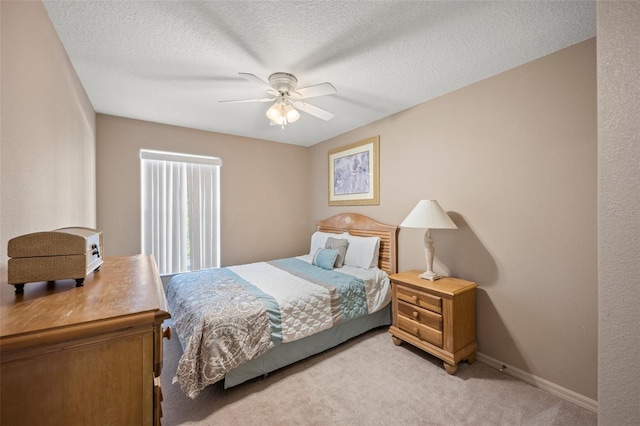 carpeted bedroom featuring a textured ceiling and ceiling fan