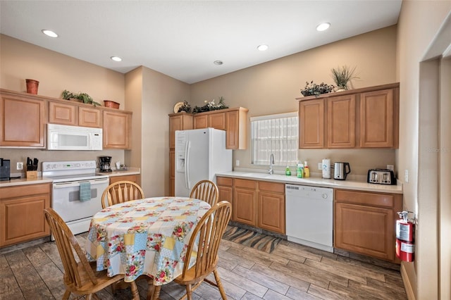 kitchen with sink, wood-type flooring, and white appliances