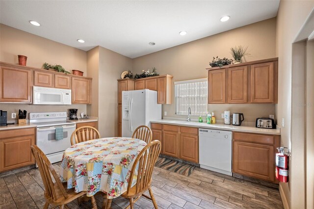 kitchen with sink, white appliances, and light hardwood / wood-style floors