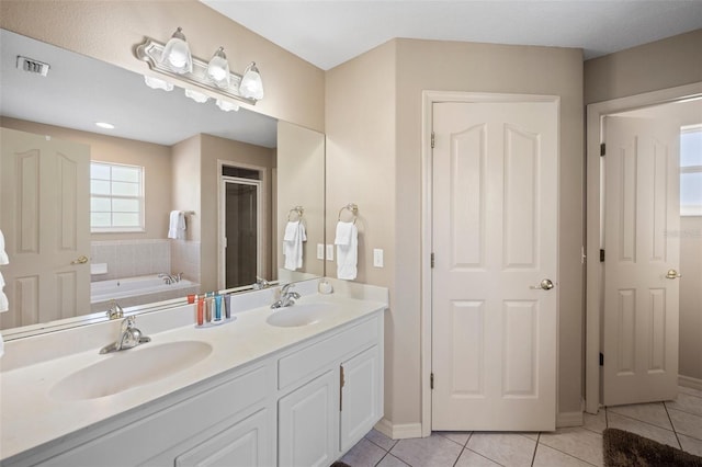 bathroom featuring dual vanity, tile patterned floors, and a washtub