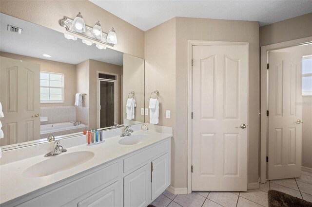 bathroom with vanity, tile patterned floors, and a tub