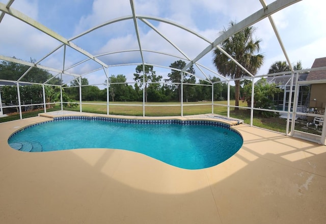 view of swimming pool featuring a yard, a patio, and a lanai