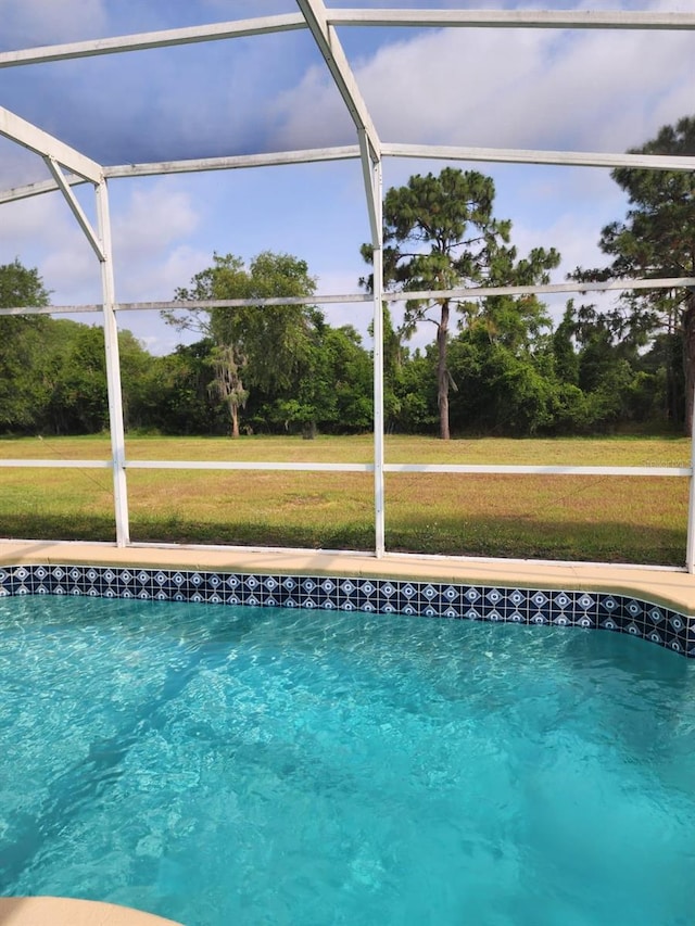 view of pool featuring a yard and a lanai