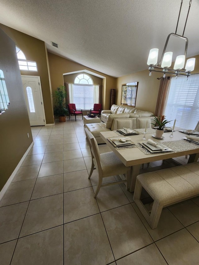 unfurnished dining area with lofted ceiling, a chandelier, a textured ceiling, and light tile patterned floors