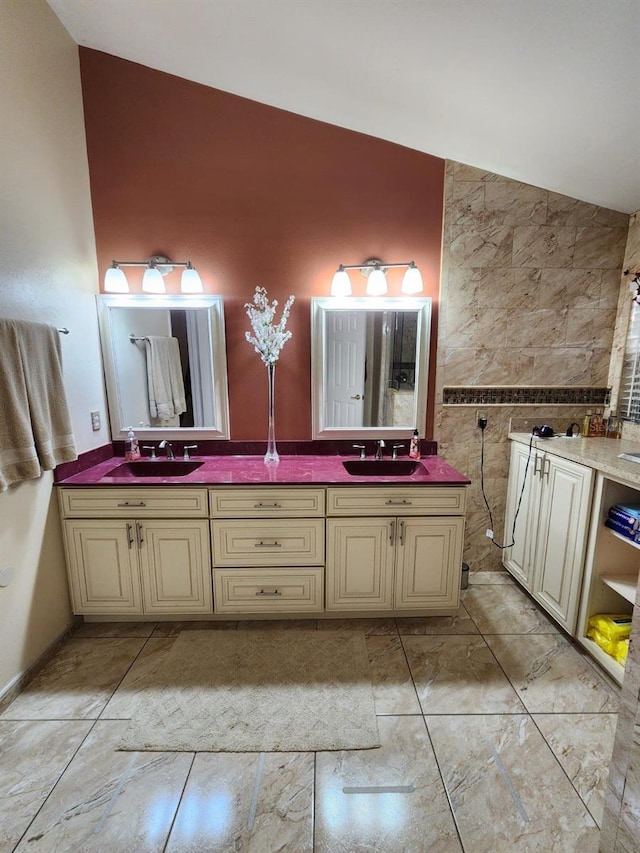 bathroom featuring vanity, lofted ceiling, and tile walls