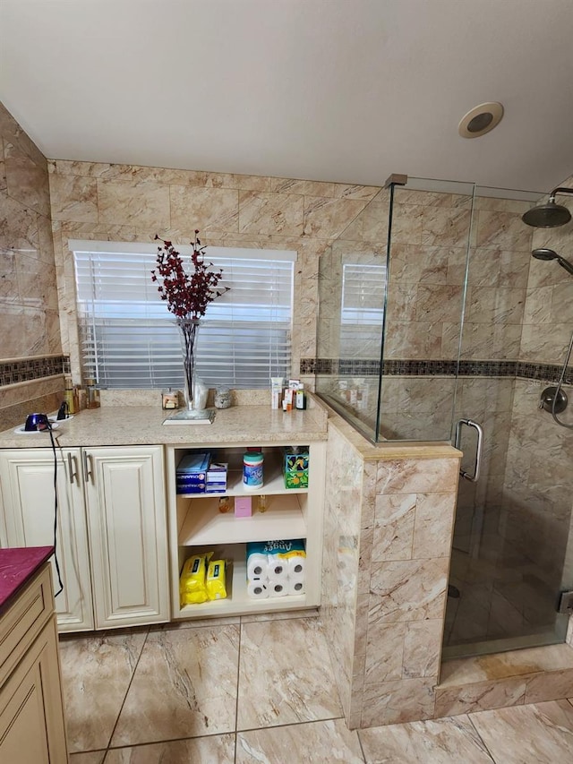 bathroom featuring vanity, walk in shower, and tile walls