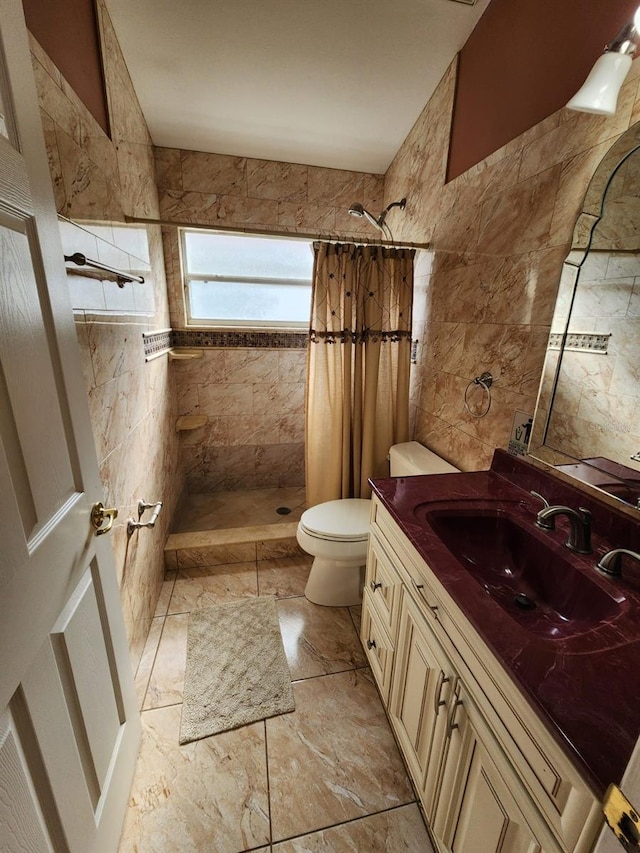 bathroom featuring vanity, walk in shower, toilet, and tile walls