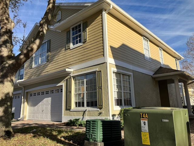 view of front of house with a garage and central air condition unit