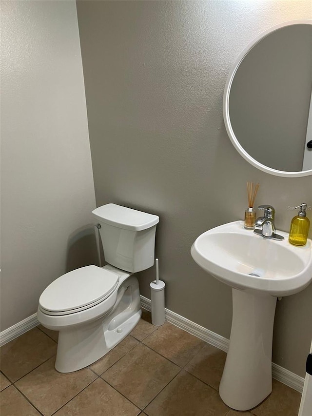 bathroom with toilet and tile floors