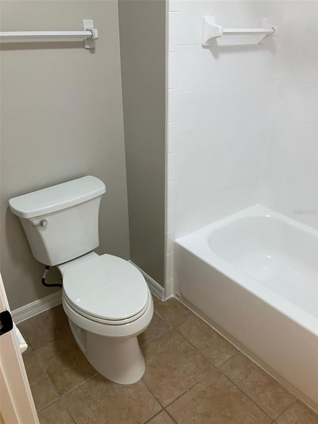 bathroom featuring tile flooring, shower / bathing tub combination, and toilet