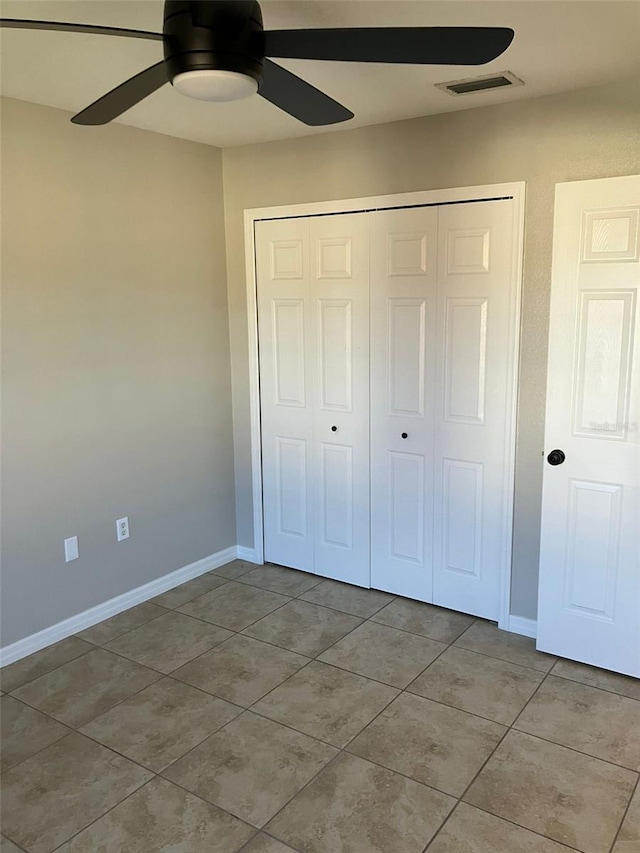 unfurnished bedroom featuring tile floors, a closet, and ceiling fan