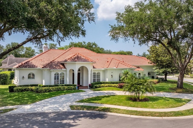 mediterranean / spanish house with a front lawn