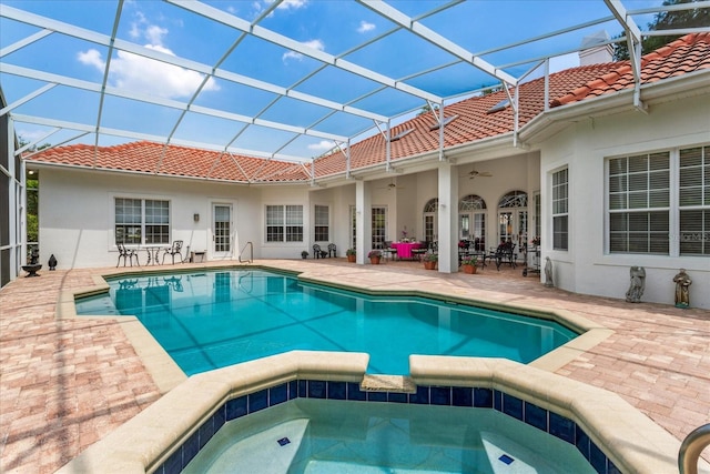 view of swimming pool featuring an in ground hot tub, a patio area, glass enclosure, and ceiling fan