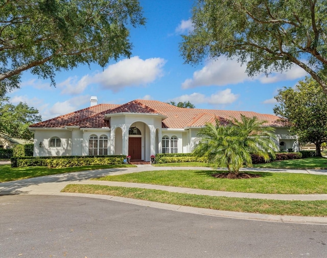 mediterranean / spanish house with a front lawn