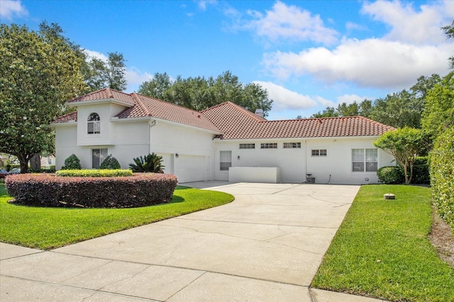 mediterranean / spanish house with a front yard and a garage