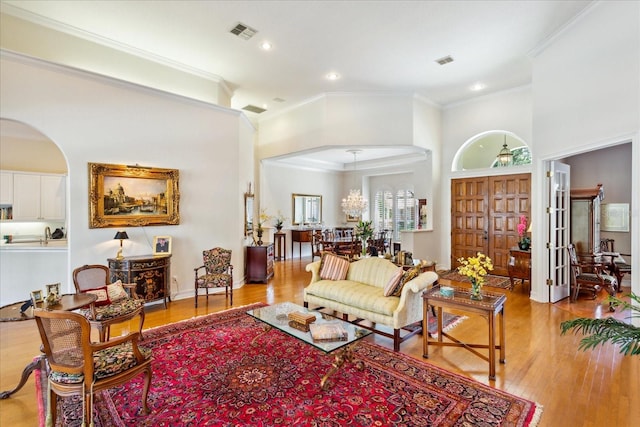 living room with french doors, light hardwood / wood-style floors, and ornamental molding